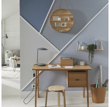 Kancelář se stolem, židlí a nástěnnou dekorací s geometrickými tvary a policemi