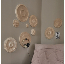 Nástěnná dekorace s ozdobnými rozetami v ložnici, sluchátka na zdi