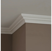 Roh místnosti s bílou ozdobnou lištou mezi stěnou a stropem