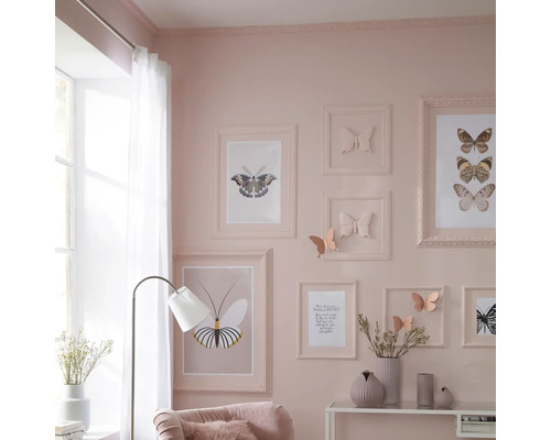 Dekorativní obývací pokoj s motivem motýlů, včetně zarámovaných obrázků, nástěnných dekorací a odpovídajících doplňků.