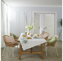 Slavnostně prostřený jídelní stůl s ratanovými židlemi na Velikonoce.