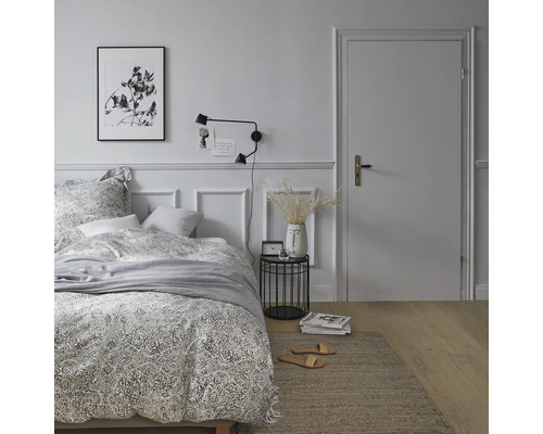 Ložnice s postelí, nočním stolkem, lampou a kobercem