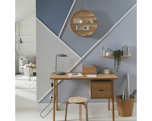 Pracovna se stolem, židlí, regály a geometrickým designem stěn