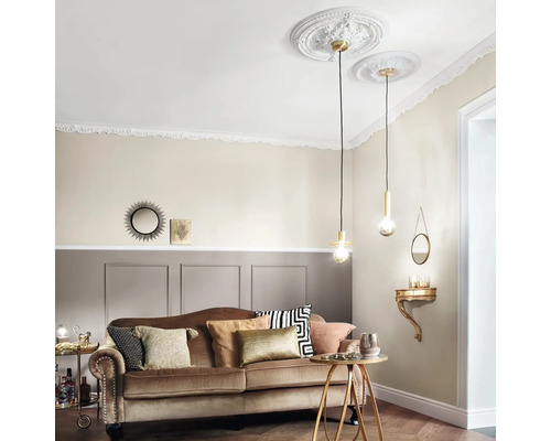 Obývací pokoj s pohovkou, odkládacím stolkem a závěsnými svítidly pod štukovými rozetami