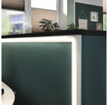 Detail osvětleného pultu s tmavou pracovní deskou