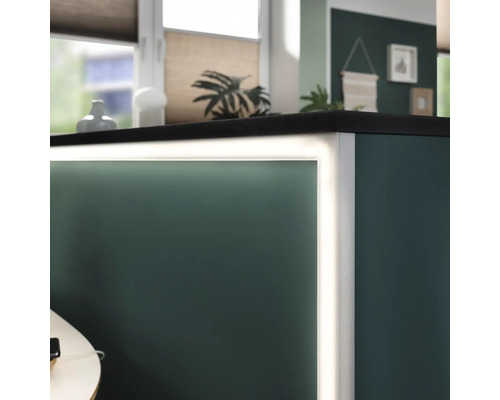 Detail osvětleného pultu s tmavou pracovní deskou