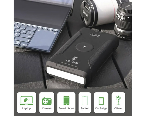 Zobrazená powerbanka s LED světlem, obklopená notebookem, fotoaparátem a objektivem.