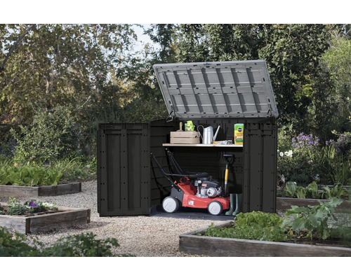 Otevřená zahradní skříň s zahradním nářadím na zahradě