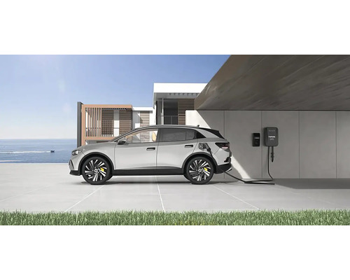 Elektromobil se nabíjí u nabíjecí stanice před moderním domem
