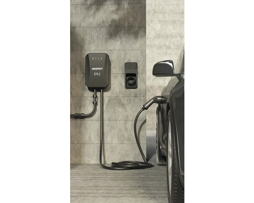 Nabíjecí stanice pro elektromobily na zdi připojená k elektrickému vozidlu