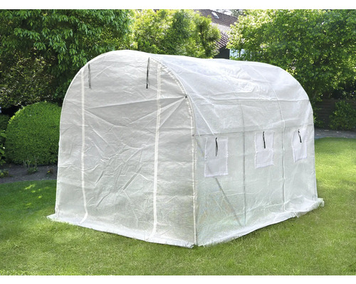 Fóliový skleník na trávníku v zahradě.