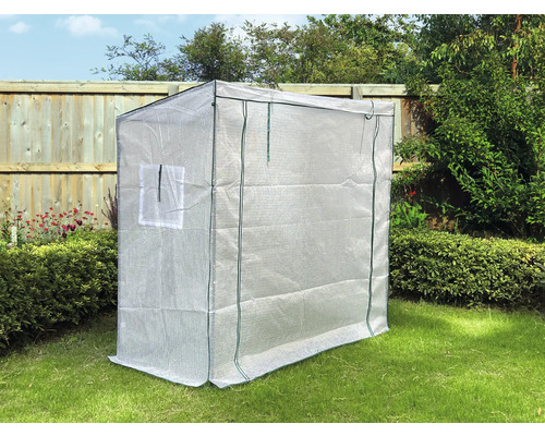 Malý skleník s průhlednou fólií na zahradě.