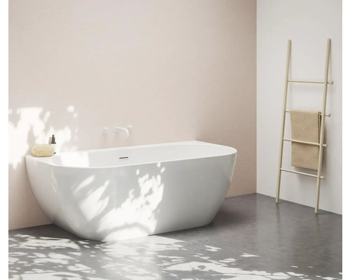 Volně stojící vana v světlé koupelně s držákem na ručníky.