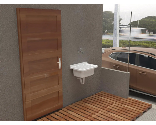 Venkovní prostor s dřevěnou podlahou, dveřmi a umyvadlem.