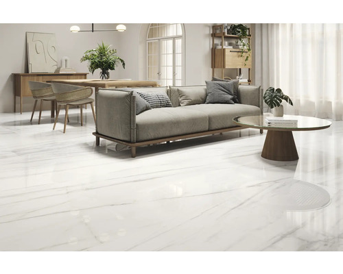 Světlá místnost s pohovkou, stolem a lesklou podlahovou krytinou s mramorovým vzhledem