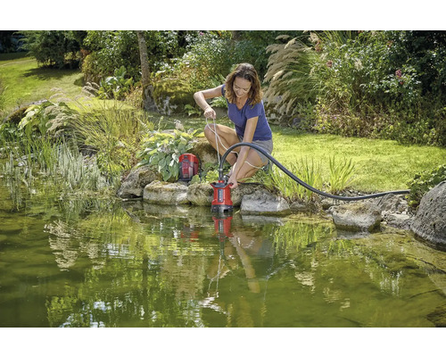 Žena používá jezírkové čerpadlo v zahradním jezírku