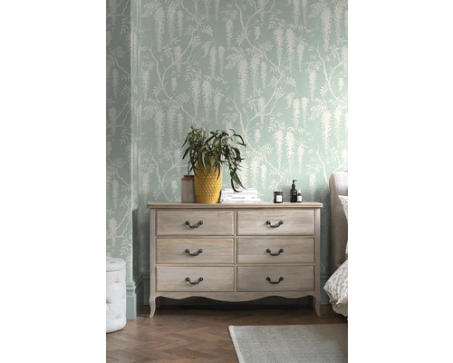 Ložnice s komodou, dekorací a vzorovanou tapetou