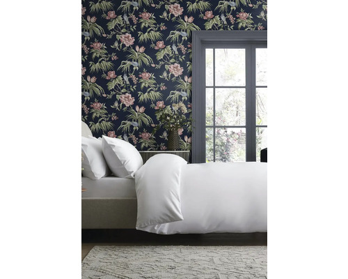 Ložnice s ložním prádlem a květinovou tapetou