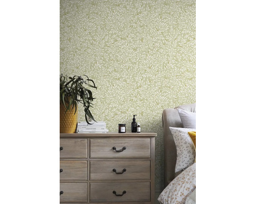 Ložnice s komodou a tapetou s motivem listů.