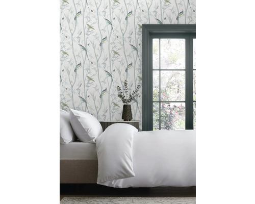 Ložnice s postelí a tapetou se vzorem ptáků a rostlin