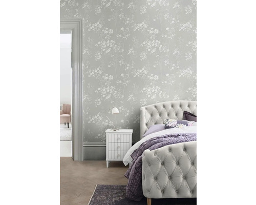 Ložnice s květinovou tapetou, postelí a nočním stolkem