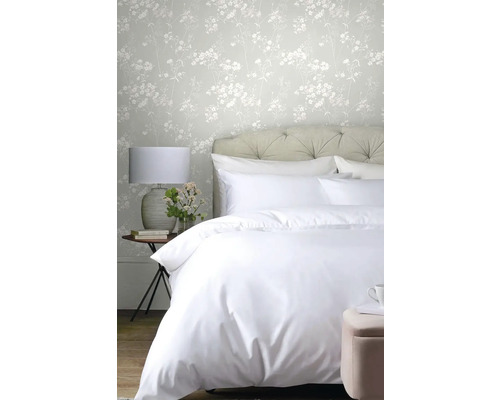 Ložnice s postelí, lampou, stoličkou a květinovou tapetou