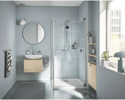 Světlá koupelna se sprchou, umyvadlem, zrcadlem a oknem pro přátelskou atmosféru