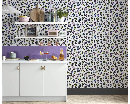 Kuchyňská scéna s tapetou s leopardím vzorem, bílými skříňkami a policemi