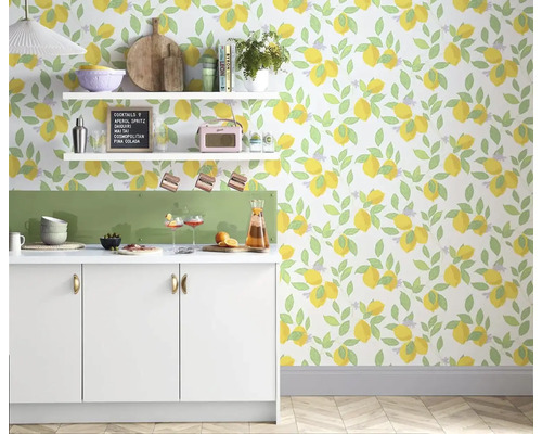 Světlá kuchyně s bílým kuchyňským pultem, policemi a tapetou s motivem citronů pro svěží atmosféru