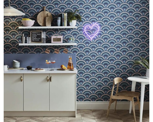 Kuchyňská scéna s vzorovanými tapetami, kuchyňskými skříňkami a dekorativními doplňky na policích.