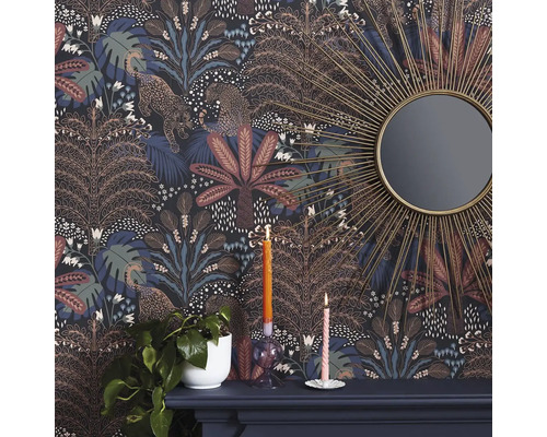 Detailní záběr místnosti s vzorovanou tapetou džungle zdobenou leopardy a stromy, spolu se zrcadlem a dekoracemi na římse krbu.