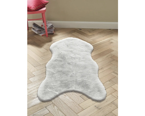 Bílý koberec na dřevěné podlaze