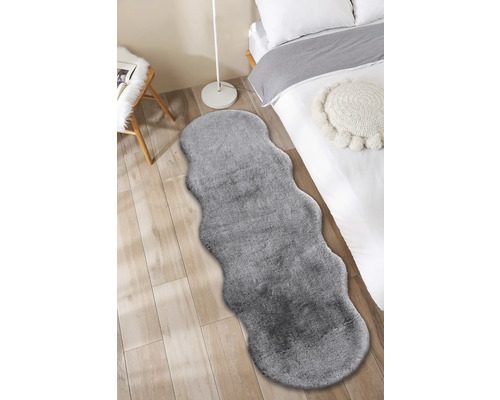 Šedý koberec v ložnici s postelí