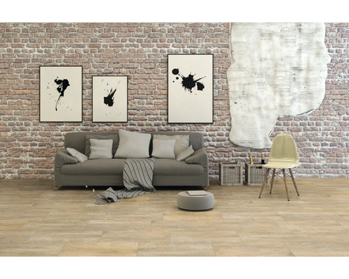 Obývací pokoj s pohovkou, židlí a nástěnnou dekorací před cihlovou zdí