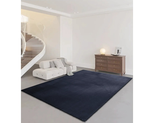 Obývací pokoj se schodištěm, pohovkou, komodou a obdélníkovým kobercem