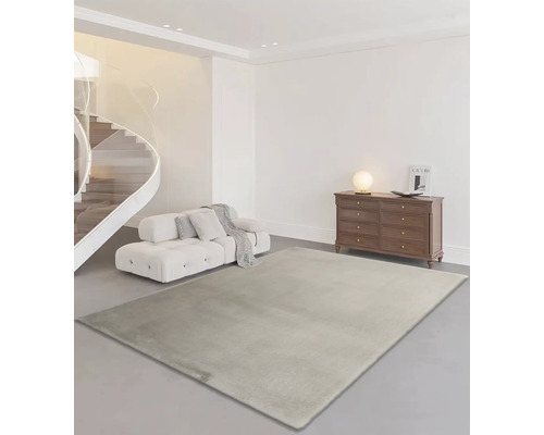 Obývací pokoj s kobercem, pohovkou, komodou a točitým schodištěm