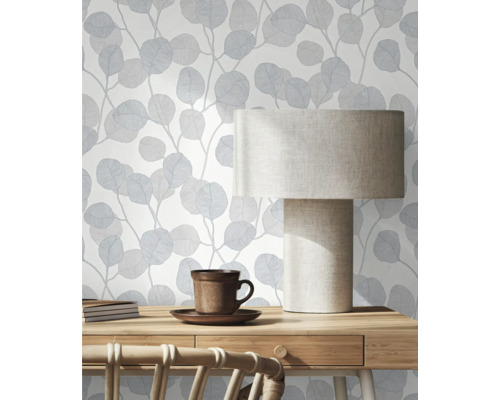 Scéna s modrou tapetou s listy, stolní lampou a psacím stolem