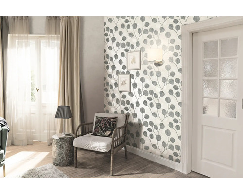Obývací pokoj s tapetou s listovými motivy, křeslem a dveřmi