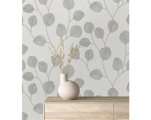 Tapeta se vzorem listů v místnosti s vázou na komodě.