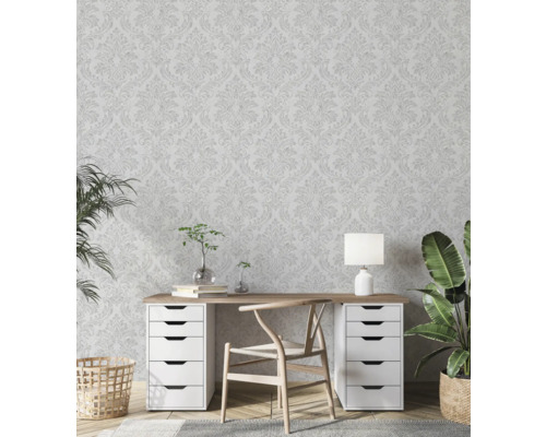 Světlá pracovna s květinovou tapetou, psacím stolem, židlí a pokojovými rostlinami