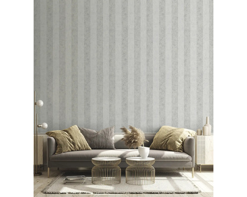 Obývací pokoj s pruhovanou tapetou, pohovkou, příručními stolky a dekorativními prvky pro stylové prostředí.