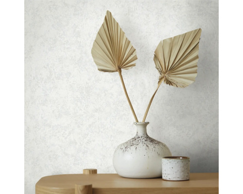 Detail bílé strukturované tapety s vázou a dekorací