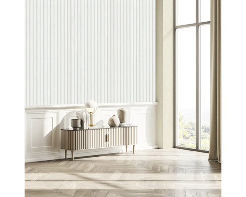 Světlý obývací pokoj s rýhovanou tapetou, příborníkem, lampou a velkým oknem