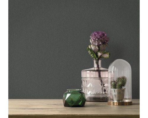 Dekorativní doplňky na stole před tmavou tapetou