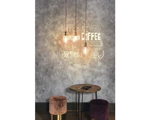 Dekorativní pokoj se závěsnými svítidly, nástěnným uměním, stolem a stoličkami.