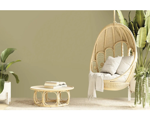 Obývací pokoj s ratanovým křeslem, stolem a rostlinami pro přírodní atmosféru