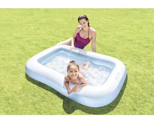 Nafukovací bazén se dvěma lidmi na trávníku.