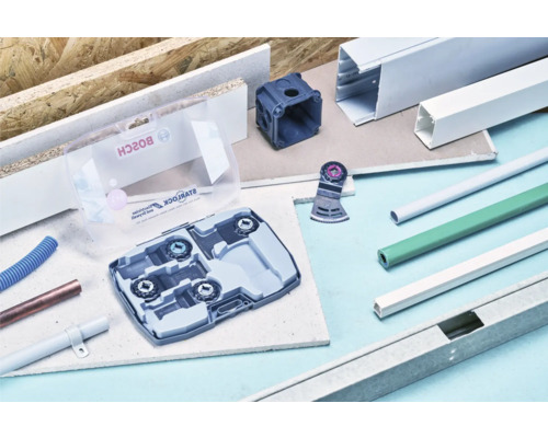 Různé stavební materiály, včetně sady nástrojů Bosch Starlock, kabelů, trubek a profilů