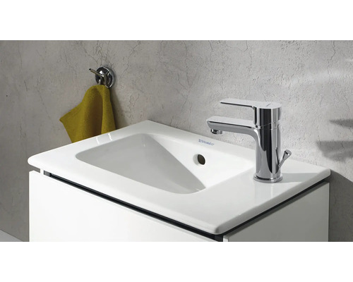 Bílé umyvadlo s baterií a držákem na ručníky