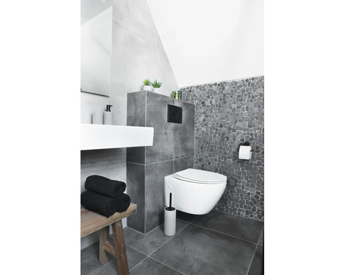 Koupelna s nástěnným záchodem, umyvadlem, lavicí a šedými dlaždicemi.